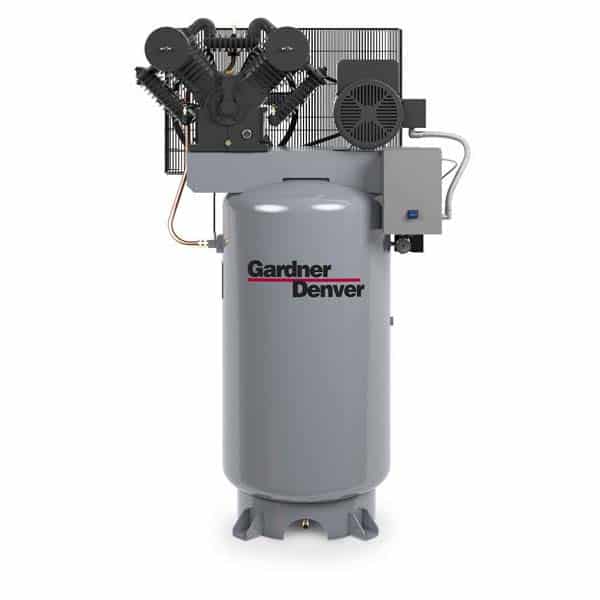 Vertical industrial air compressor with gray tank, black unit on top, cooling fins, motor, control box; tank labeled Gardner Denver.